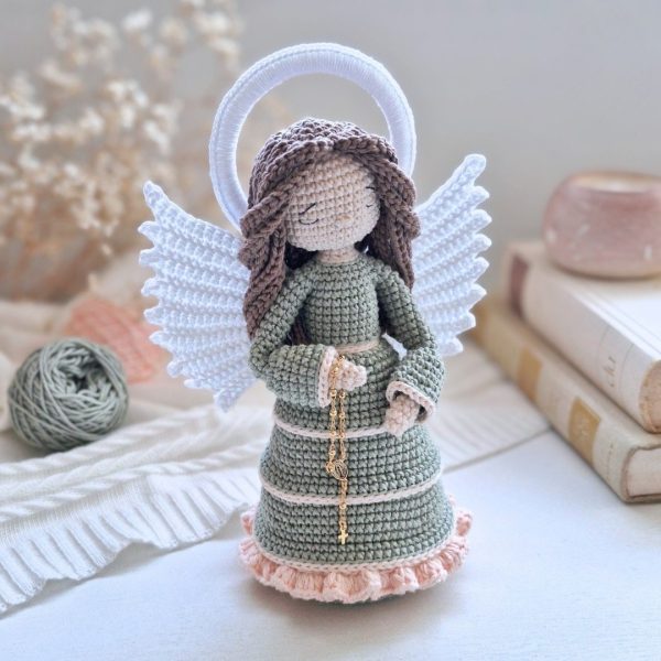 Anjo em amigurumi com rosário, asas brancas e veste verde em crochê artesanal