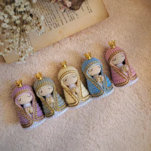 Mini Nossa Senhora em Amigurumi confeccionada com fios, manto e coroa. Projeto autoral em PDF.