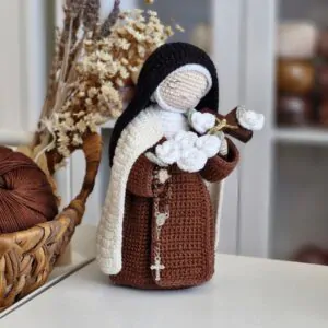 Santa Teresinha do Menino Jesus em amigurumi sem crucifixo, rosas ou rosário, destacando a estrutura do hábito carmelita e a construção da peça.